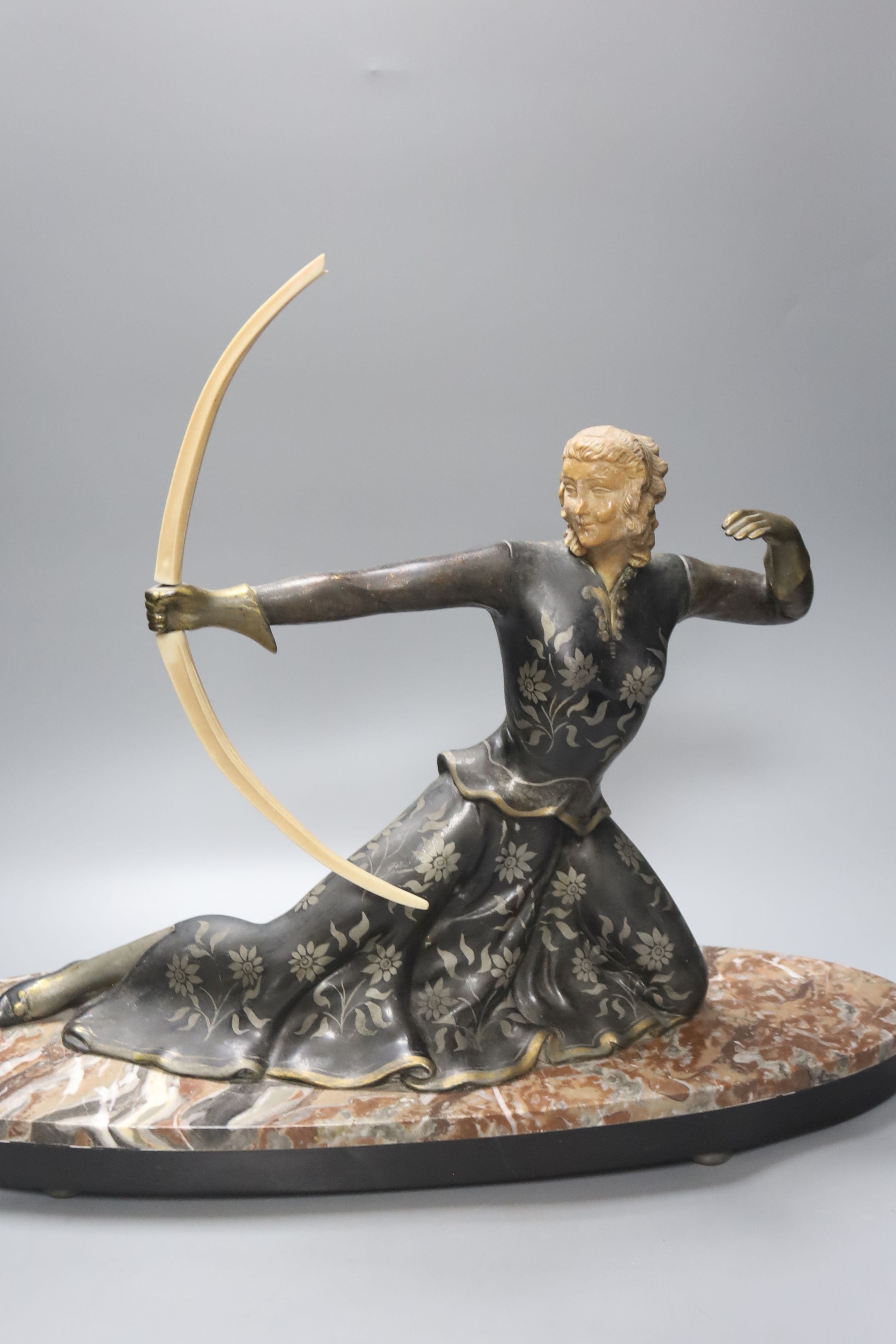 An Art Deco style spelter and marble figure of a female archer, base length 55cm